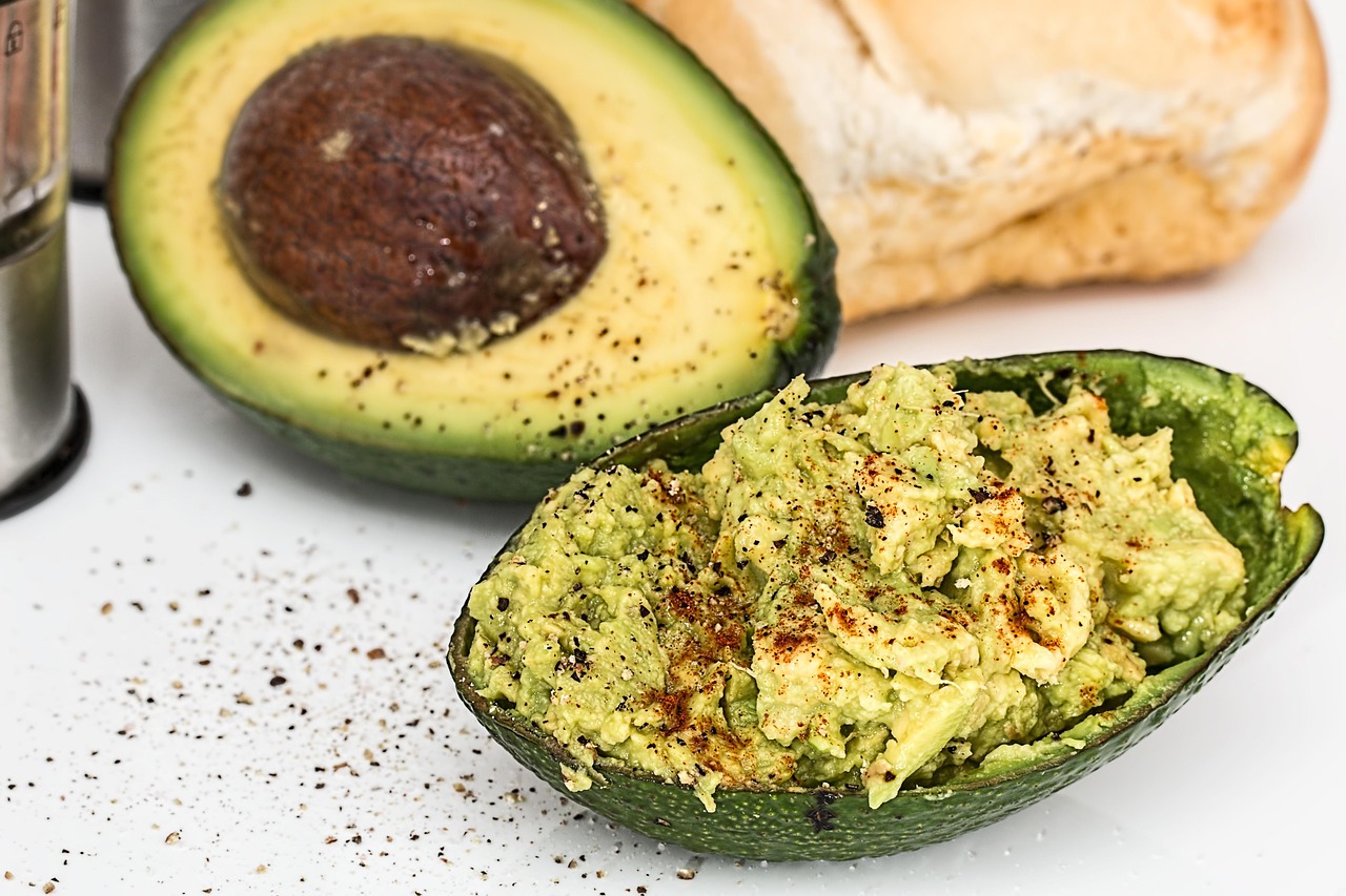 Avocado su un tagliere con ingredienti naturali per abbassare il colesterolo, in un contesto di cucina casalinga.