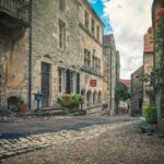 Un incantevole villaggio francese con stradine pittoresche e case in pietra, simbolo di storia e bellezza.